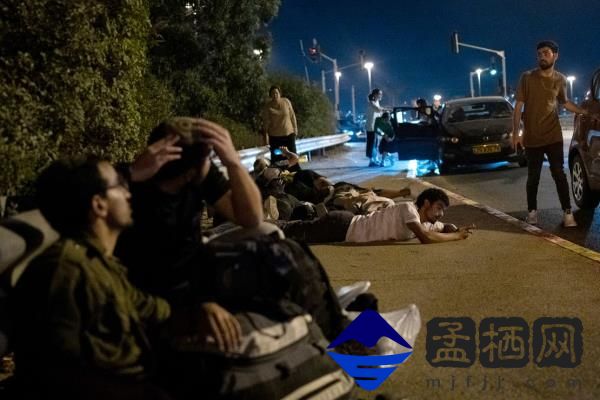 Israelis take cover as projectiles launched from Iran are intercepted in the skies over Rosh Haayin.